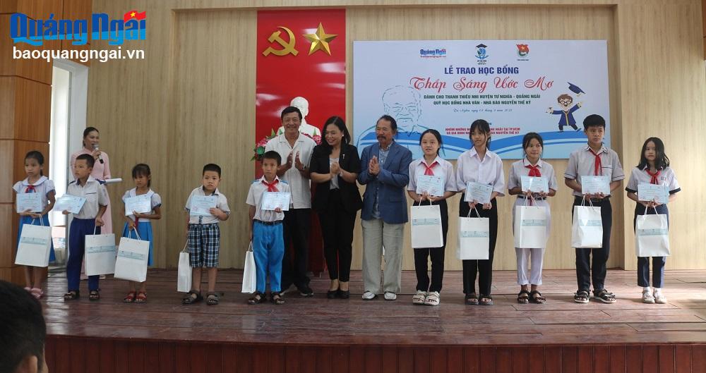 Con gái cố nhà văn, nhà báo Nguyễn Thế Kỷ Nguyễn Thị Hải Hằng (áo đen) và các thành viên trong Nhóm những người bạn Quảng Ngãi tại TP.Hồ Chí Minh trao học bổng cho học sinh.